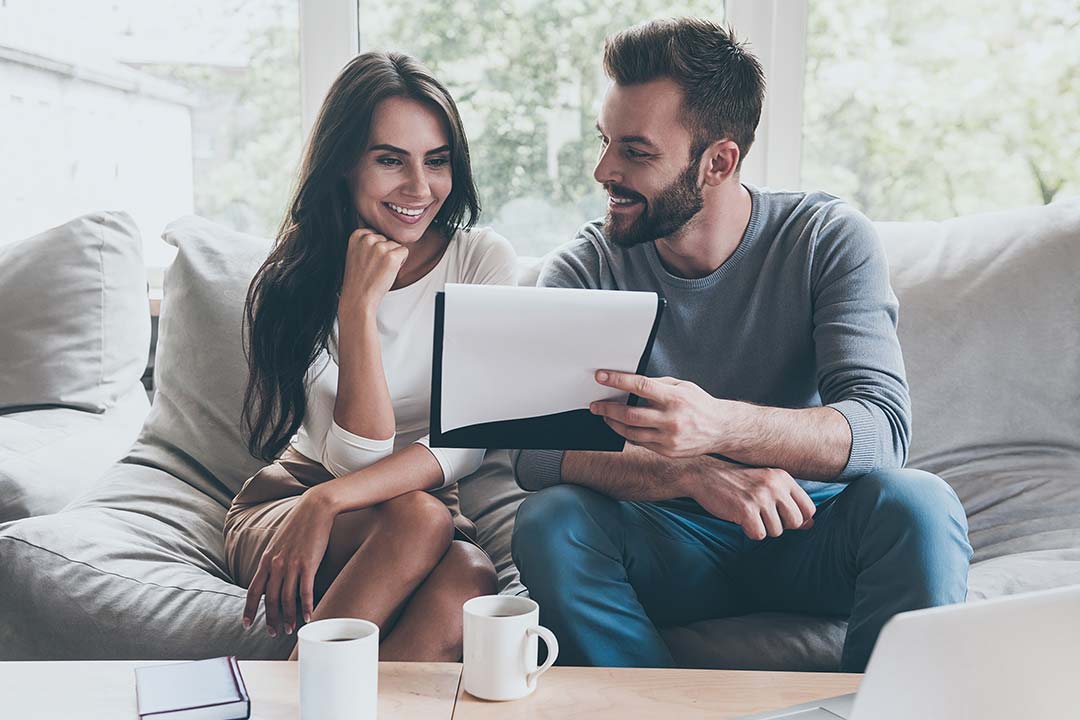 Couple satisfait devant les plans de leur futur logement