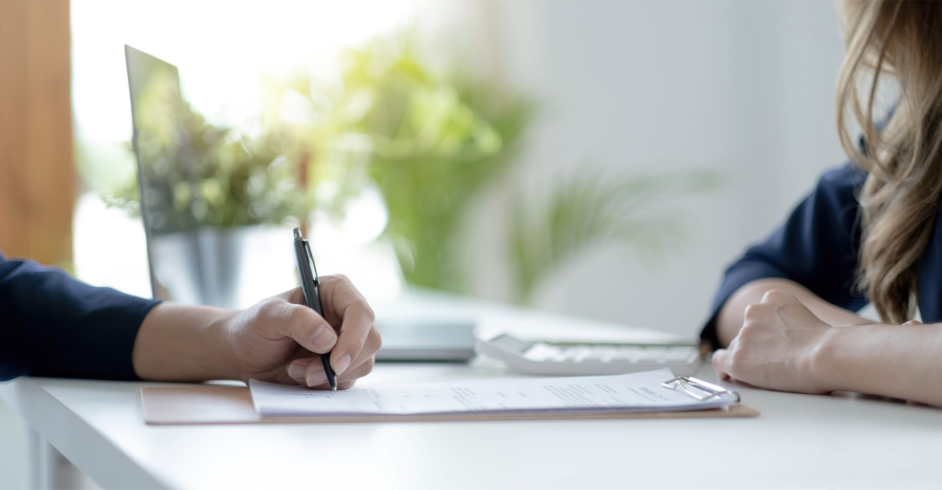 Un futur acquéreur en train de signer son offre de crédit immobilier