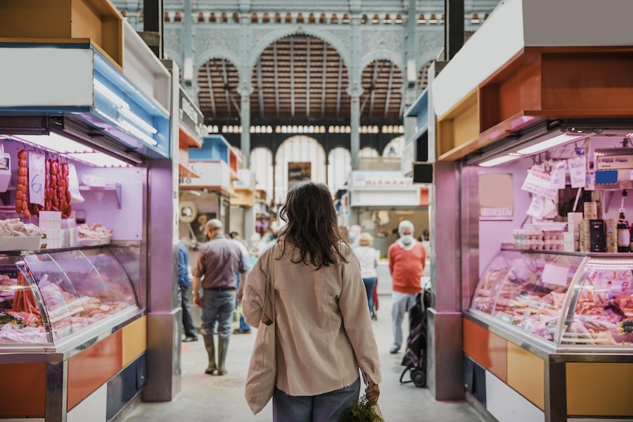 une femme en train de se promener dans un marché couvert proche de son logement neuf