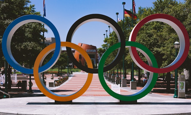 les 5 anneaux olympiques sont posés sur une place.