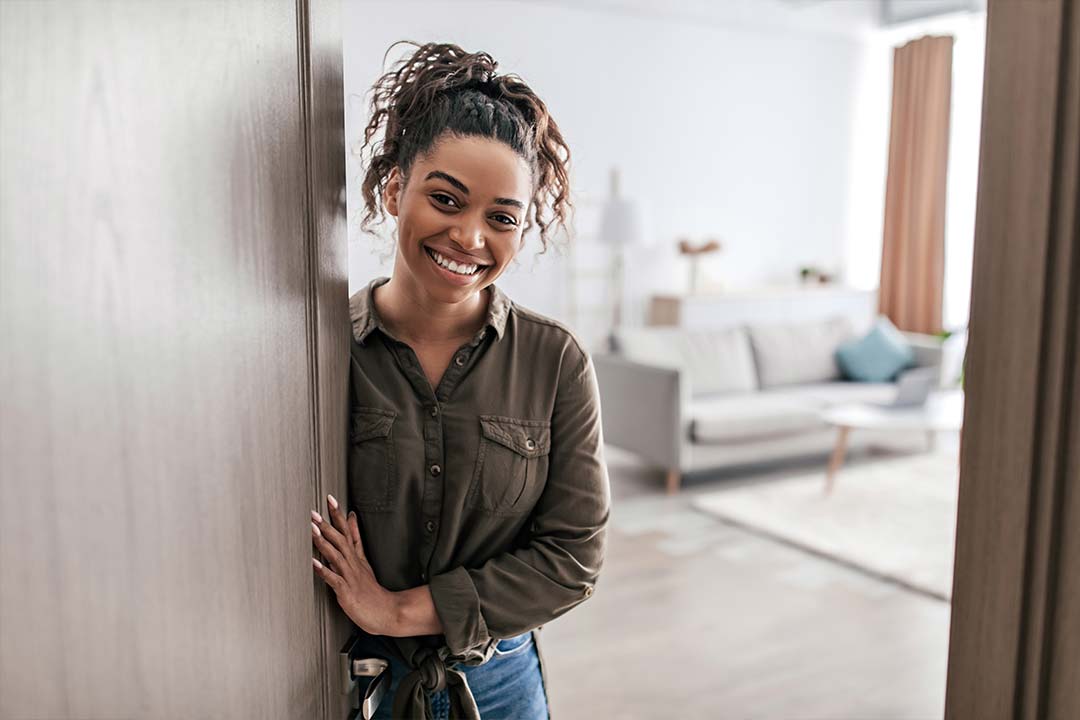 Jeune femme propriétaire ouvrant la porte d'entrée