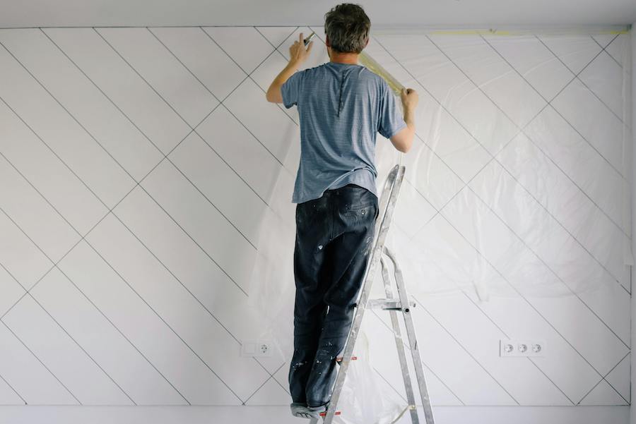 un ouvrier du bâtiment en train d’effectuer des travaux de rénovation dans un logement