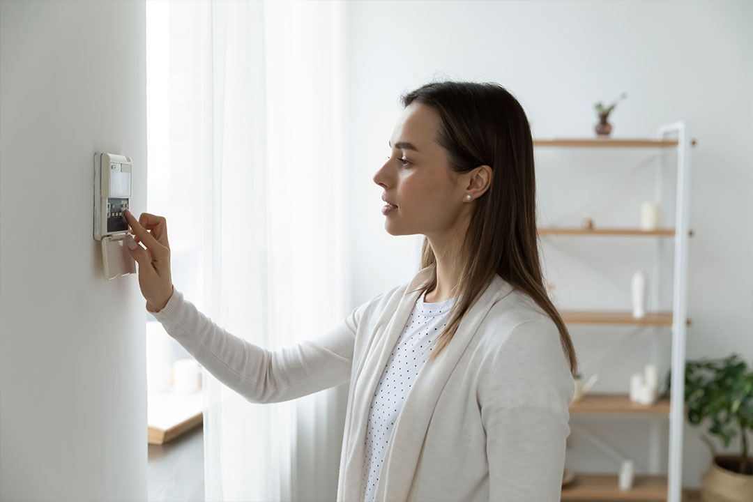 Une femme règle la température de son logement