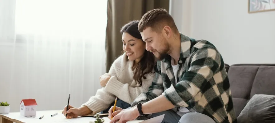 un jeune couple heureux d’avoir acheté un logement neuf pour faire du locatif