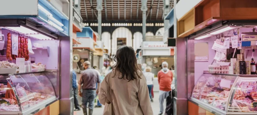 une femme en train de se promener dans un marché couvert proche de son logement neuf