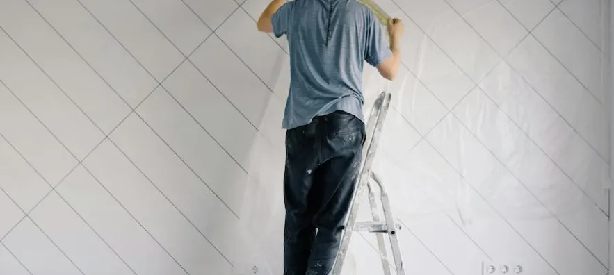 un ouvrier du bâtiment en train d’effectuer des travaux de rénovation dans un logement