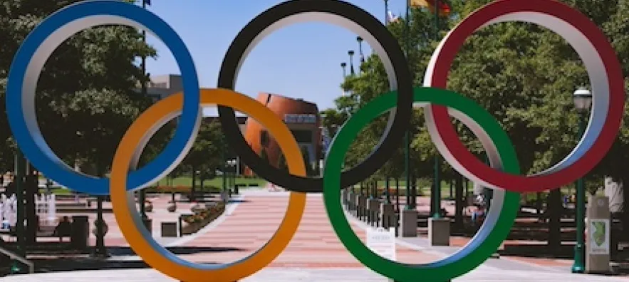 les 5 anneaux olympiques sont posés sur une place.