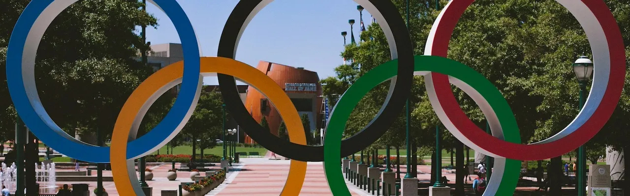 les 5 anneaux olympiques sont posés sur une place.