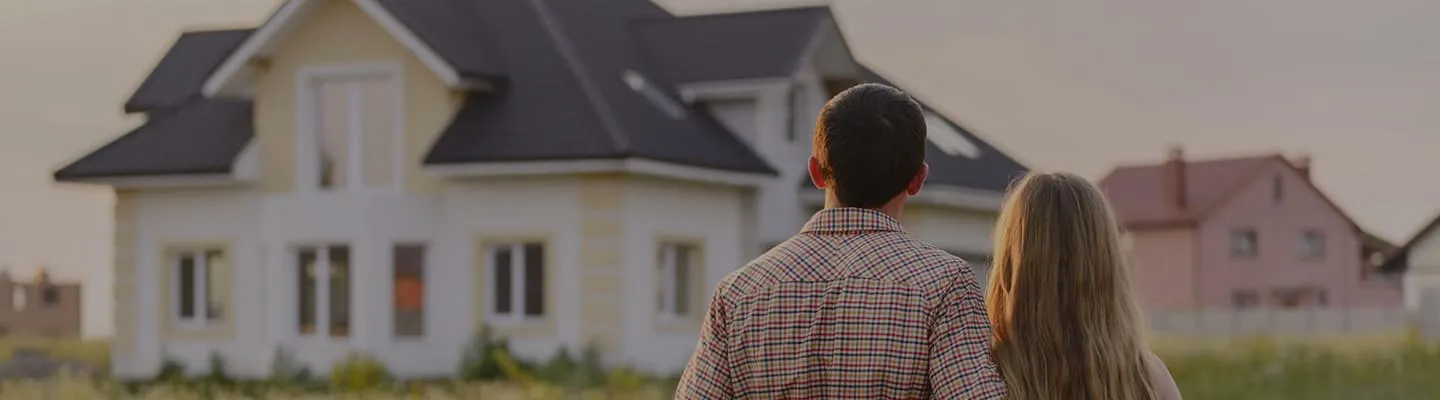 Couple s'enlaçant devant une maison