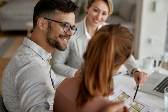 Happy man and his wife having a meeting with real estate agent in the office.