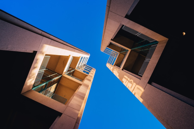 Vue aérienne de deux immeubles résidentiels modernes de type HLM sous un ciel bleu, illustrant l'urbanisme vertical et le logement collectif