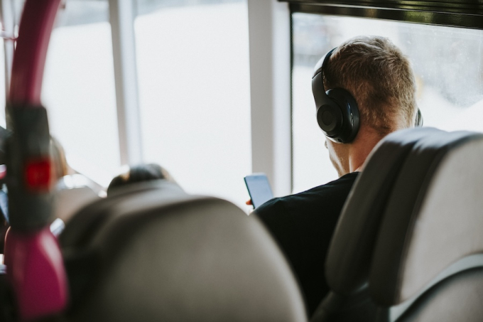 Passager avec casque audio utilisant son smartphone dans un bus TBM à Bordeaux