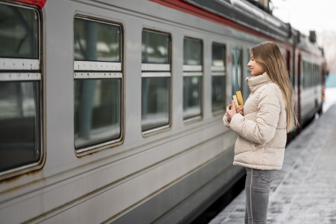 Jeune femme en train d’attendre le tram sur le quai, illustration de la mobilité facilitée par le futur Tram des Nations